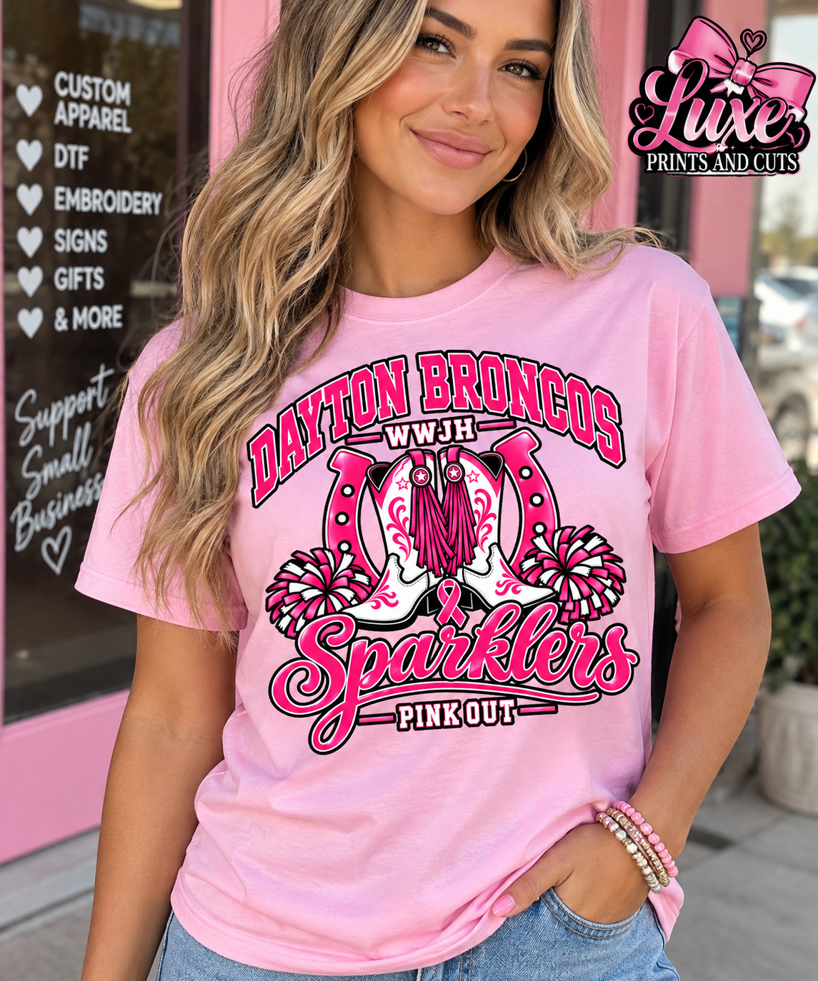 Woman wearing light pink Dayton Broncos WWJH Sparklers shirt
